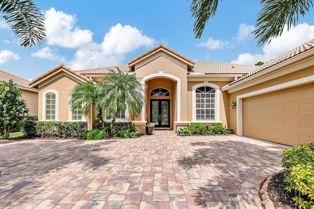 mediterranean / spanish-style house featuring french doors and a garage