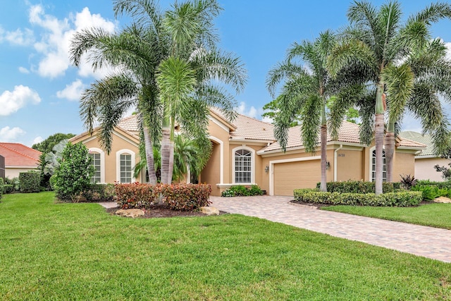 mediterranean / spanish-style house with a front yard and a garage