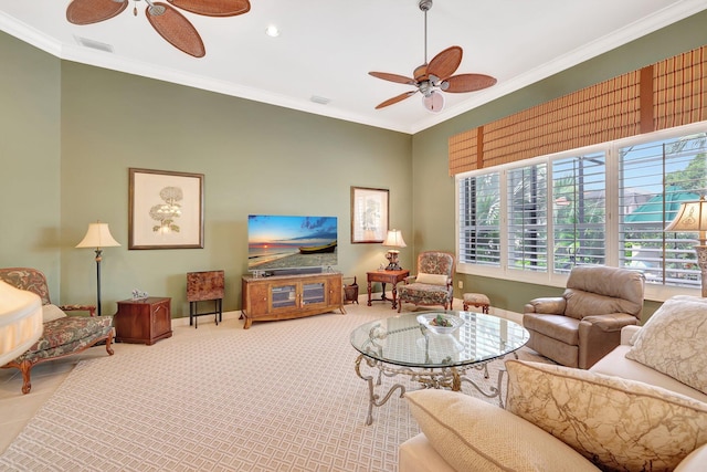 carpeted living room with ornamental molding and ceiling fan