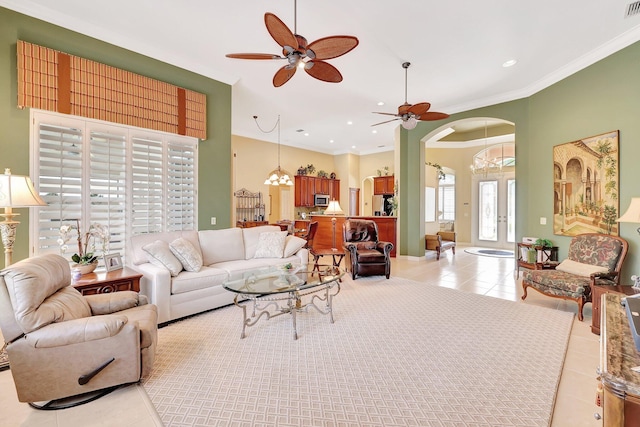 living room with ornamental molding, ceiling fan with notable chandelier, and light tile patterned floors