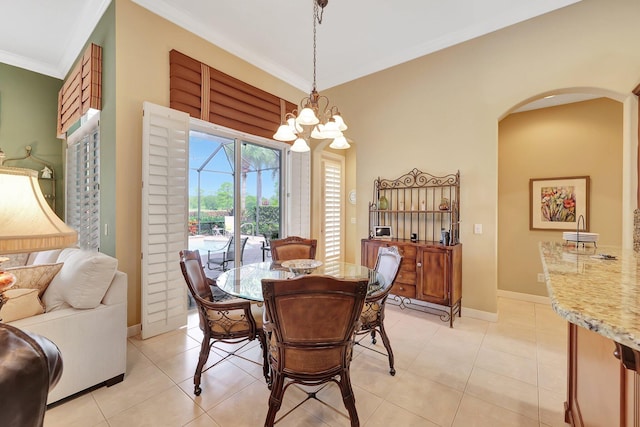 tiled dining space featuring a notable chandelier and crown molding