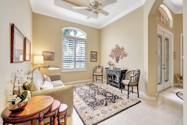 living area with ceiling fan, light tile patterned floors, french doors, and ornamental molding