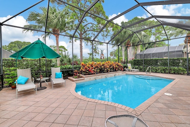 view of pool with glass enclosure and a patio area