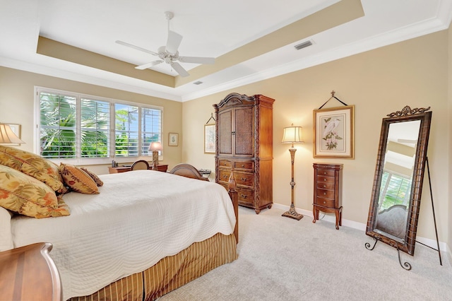 carpeted bedroom featuring ornamental molding, a tray ceiling, and ceiling fan