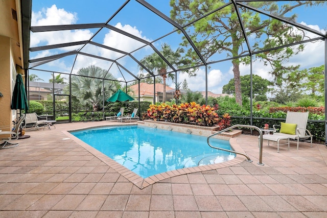 view of pool featuring glass enclosure and a patio area