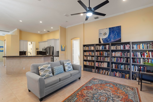 living room with ornamental molding, light tile patterned flooring, and ceiling fan