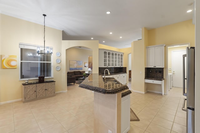 kitchen featuring kitchen peninsula, hanging light fixtures, sink, white cabinets, and a kitchen breakfast bar