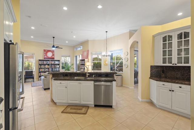 kitchen with sink, appliances with stainless steel finishes, white cabinets, and dark stone counters