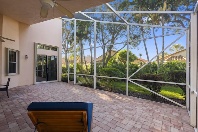 unfurnished sunroom with ceiling fan