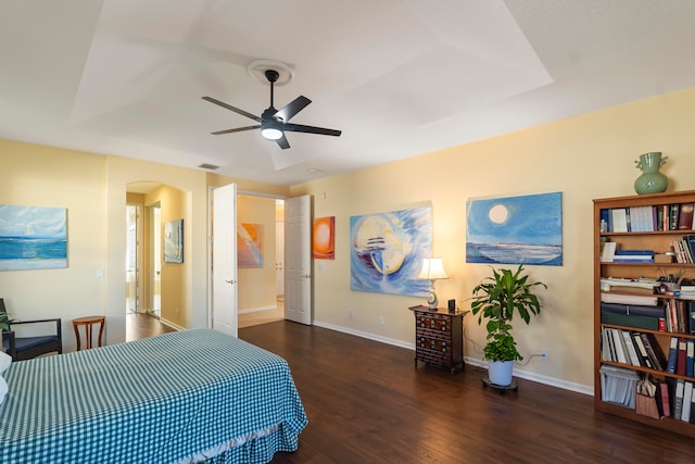 bedroom with dark hardwood / wood-style floors, ensuite bathroom, and ceiling fan