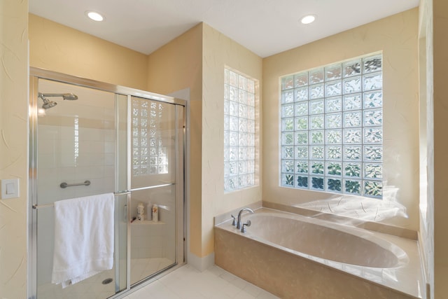 bathroom featuring a healthy amount of sunlight, plus walk in shower, and tile patterned flooring