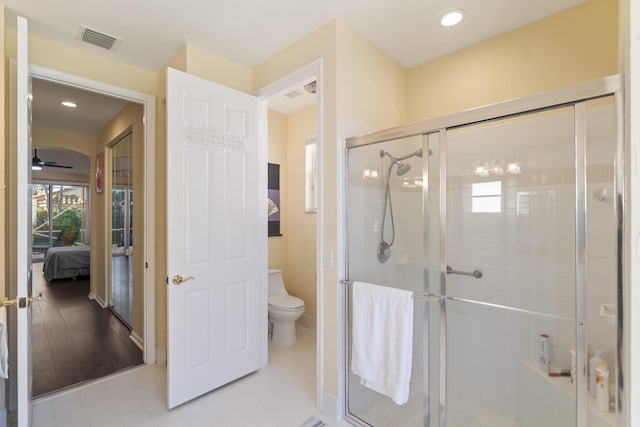 bathroom with ceiling fan, an enclosed shower, tile patterned flooring, and toilet