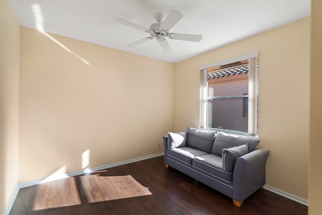 living area with dark wood-type flooring and ceiling fan