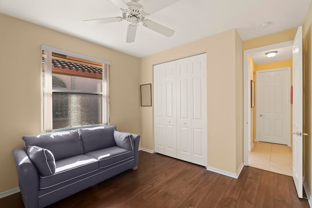 living area with ceiling fan and dark hardwood / wood-style flooring