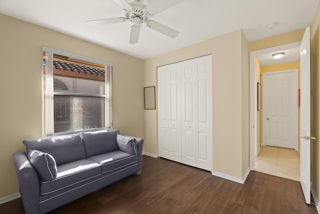 living area featuring ceiling fan and dark wood-type flooring