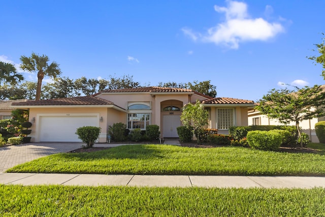 mediterranean / spanish-style house with a garage and a front lawn