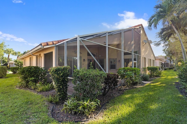 back of house featuring a yard, a lanai, and ceiling fan