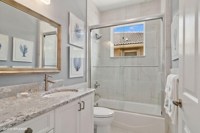 full bathroom with vanity, toilet, and bath / shower combo with glass door