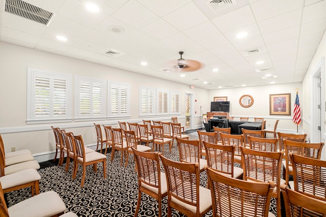 dining area with a drop ceiling and ceiling fan