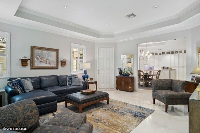 living room with an inviting chandelier, a raised ceiling, and crown molding