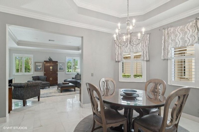 dining area with ornamental molding, a raised ceiling, and an inviting chandelier