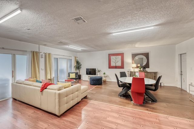 living room with light hardwood / wood-style floors and a textured ceiling