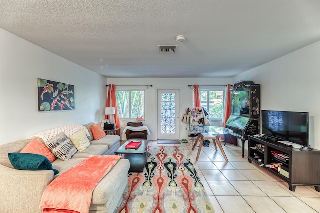 living room featuring a textured ceiling, a healthy amount of sunlight, and light tile patterned flooring