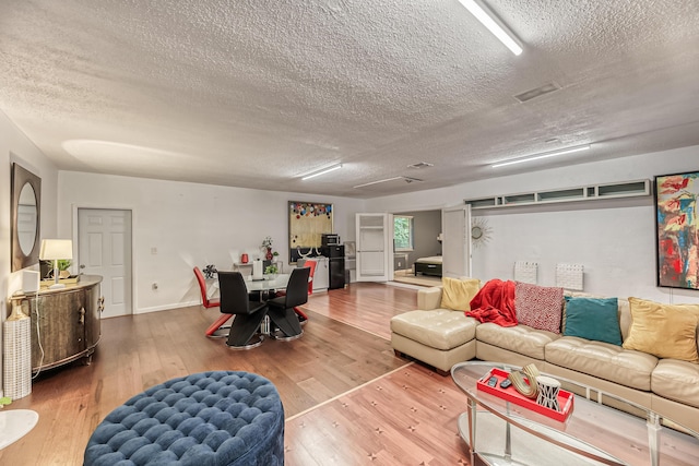 living room with wood-type flooring and a textured ceiling