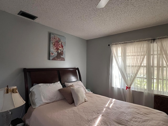 bedroom featuring ceiling fan and a textured ceiling