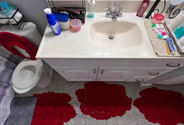 bathroom with tile patterned flooring, vanity, and toilet