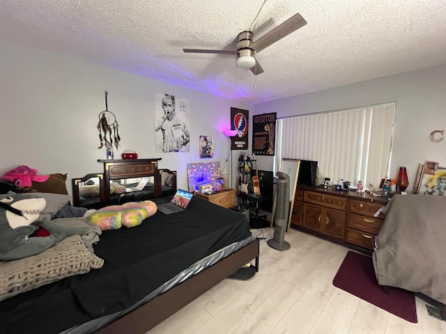 bedroom with a textured ceiling, light hardwood / wood-style floors, and ceiling fan