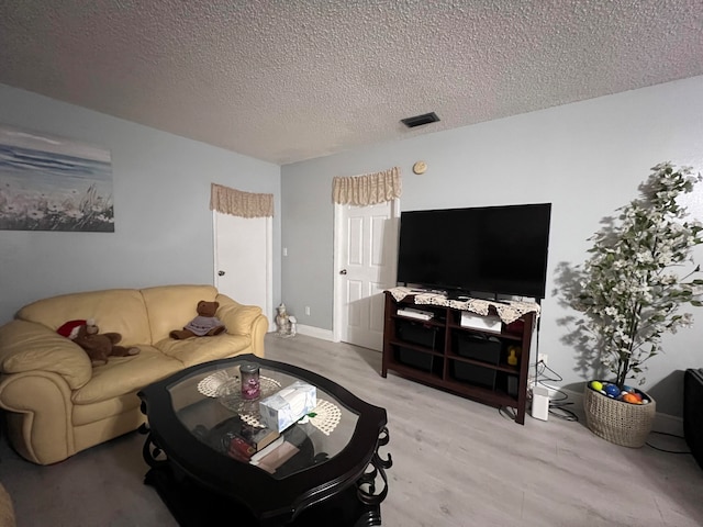 living room featuring a textured ceiling and light hardwood / wood-style flooring