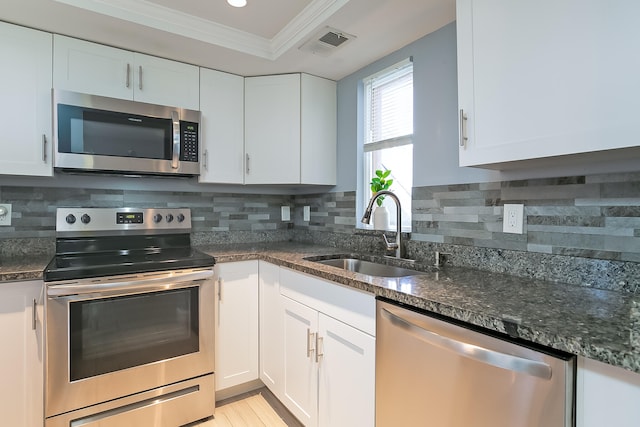 kitchen with white cabinets, crown molding, sink, and stainless steel appliances