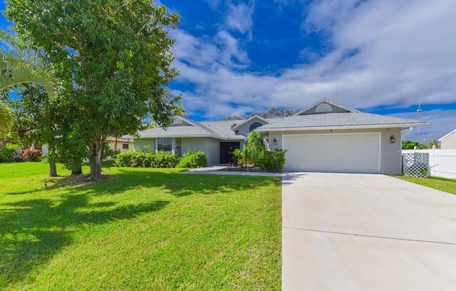 ranch-style home featuring stucco siding, an attached garage, concrete driveway, and a front yard