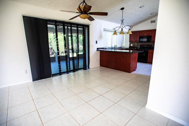 kitchen with black appliances, a kitchen breakfast bar, vaulted ceiling, decorative light fixtures, and light tile patterned floors