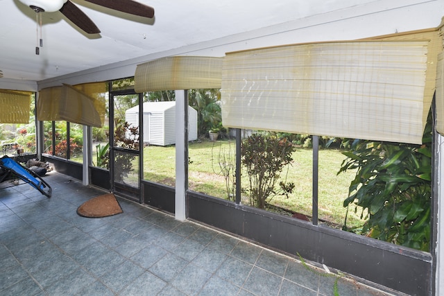 unfurnished sunroom featuring ceiling fan and a wealth of natural light