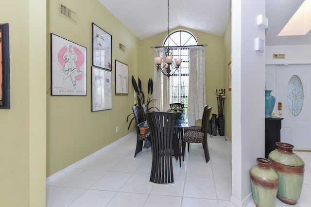 tiled dining space featuring a notable chandelier and lofted ceiling