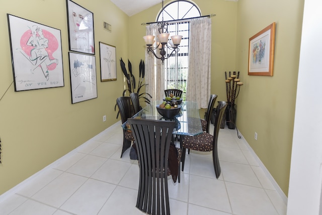 dining space featuring an inviting chandelier, vaulted ceiling, and light tile patterned floors