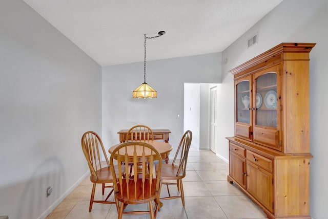 dining area with vaulted ceiling and light tile patterned floors