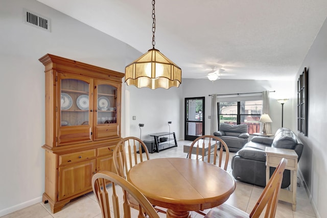 tiled dining room with lofted ceiling and ceiling fan