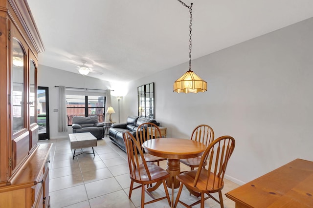 tiled dining room with ceiling fan and lofted ceiling