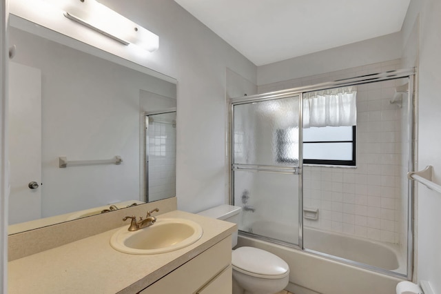 full bathroom with combined bath / shower with glass door, vanity, and toilet