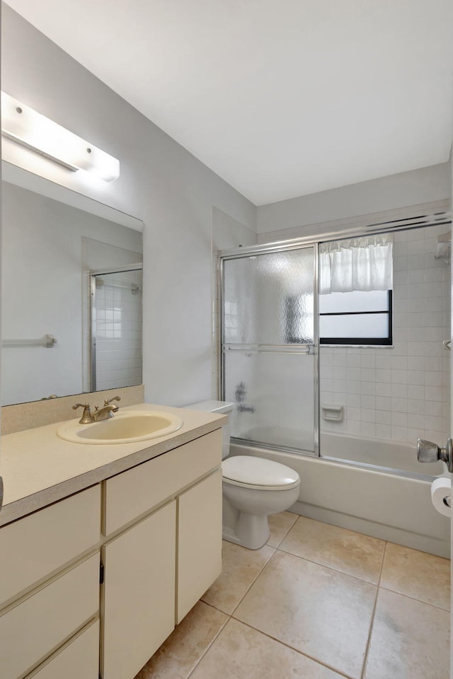 full bathroom featuring enclosed tub / shower combo, vanity, tile patterned flooring, and toilet