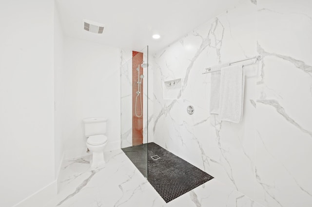 bathroom featuring a tile shower and toilet