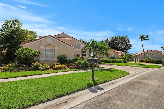 mediterranean / spanish-style house featuring a front yard