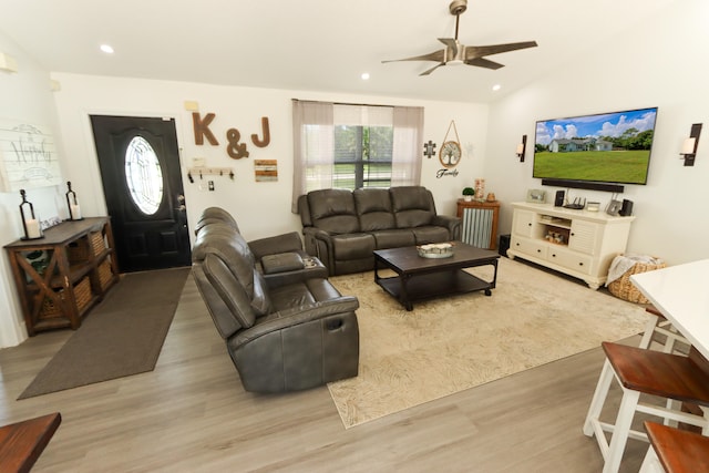 living room with light wood-type flooring, vaulted ceiling, and ceiling fan