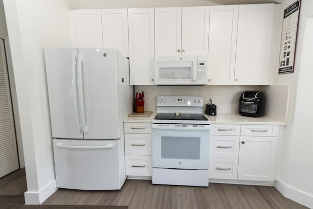 kitchen featuring white appliances, light hardwood / wood-style flooring, and white cabinets