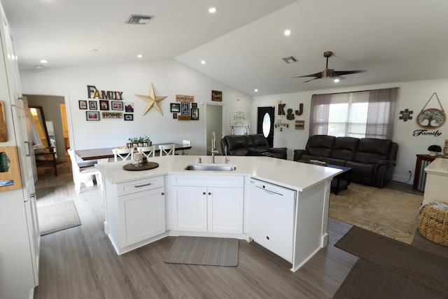 kitchen with dishwasher, sink, an island with sink, white cabinets, and vaulted ceiling