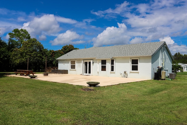 rear view of house with a fire pit, a patio area, and a yard