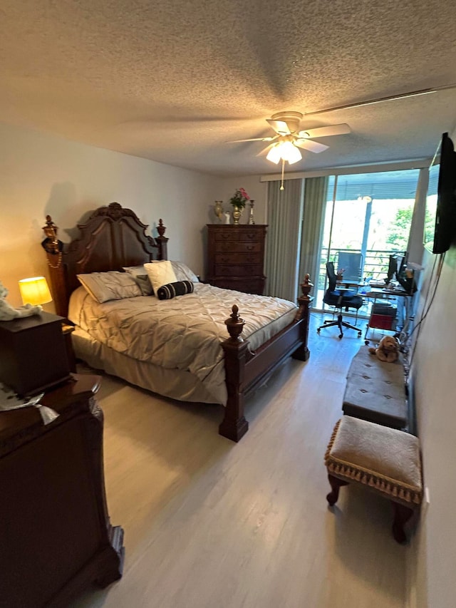 bedroom with wood-type flooring, a textured ceiling, ceiling fan, and floor to ceiling windows